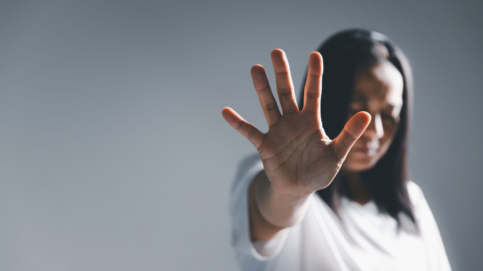 mujer con la mano extendida contra la violencia de género