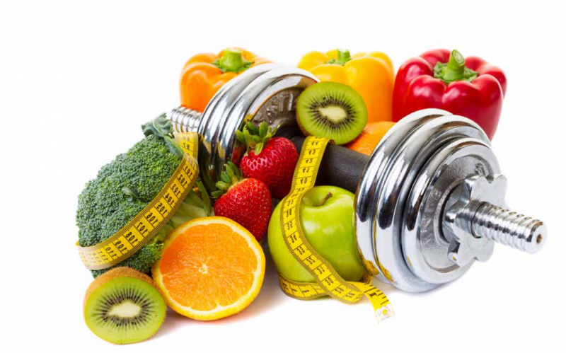 mancuerna de fitness rodeada por un metro y alimentos de origen vegetal